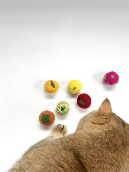 Cat playing with handmade felt cat balls from the Fortune Fruit Box collection