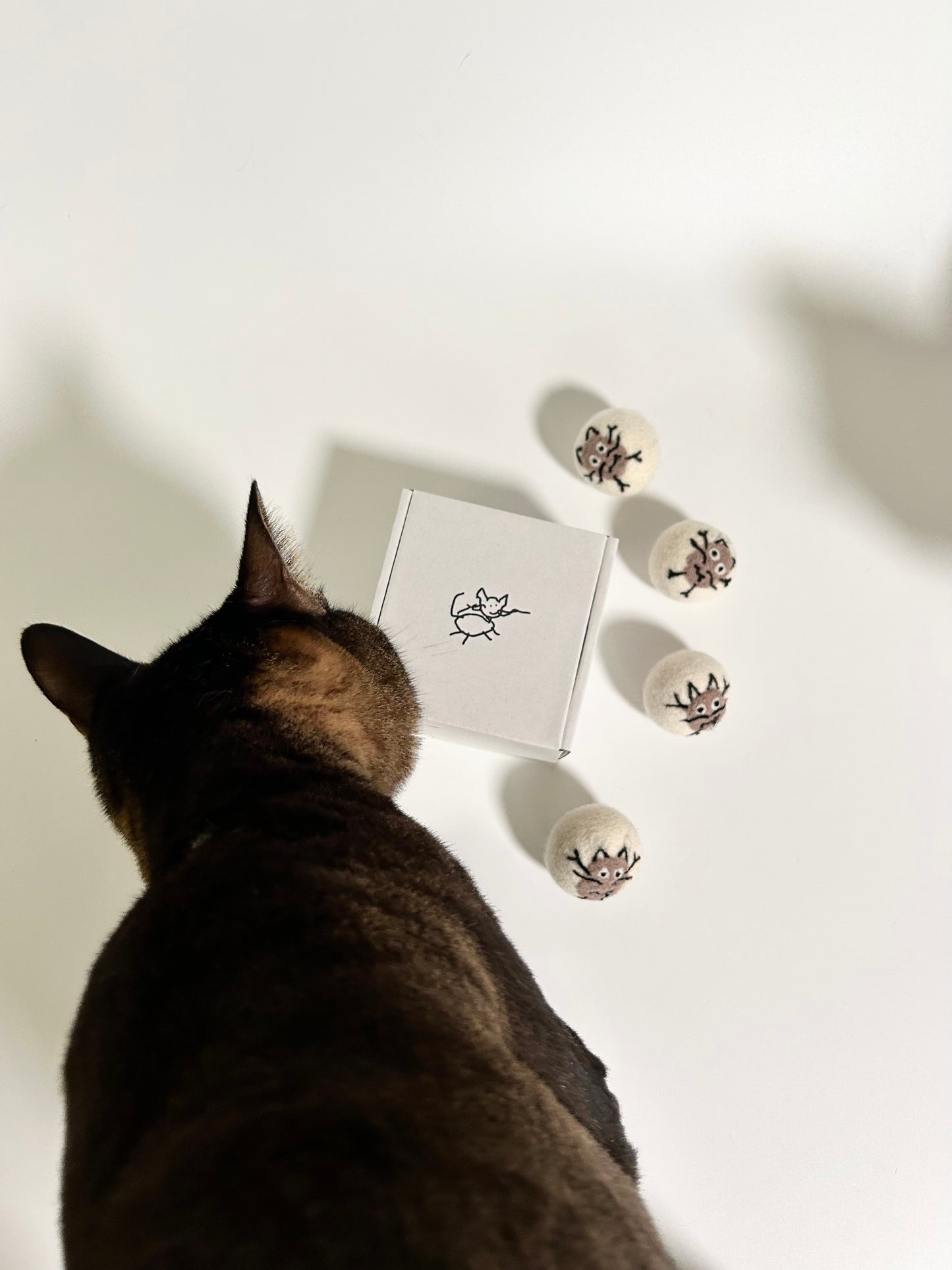 Indoor cat playing with Potato Meow handmade felt toy balls