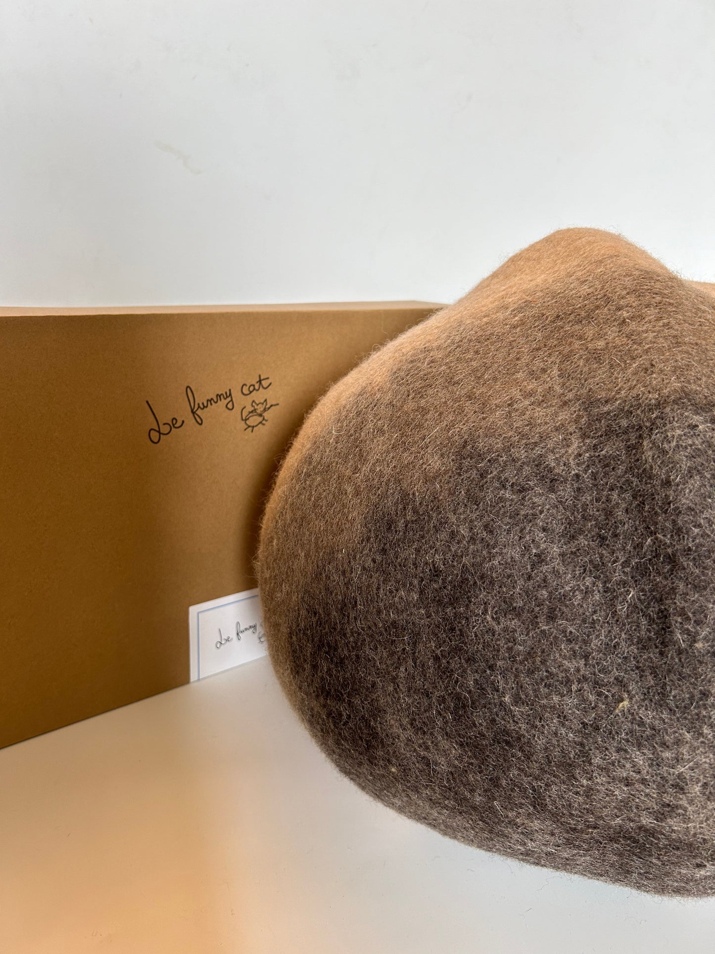 Cat relaxing inside the A Chestnut handmade felt cat cave